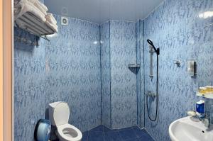 a bathroom with a shower and a toilet and a sink at Hotel Lazuri in Kvariati