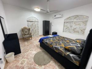 a bedroom with a bed and a chair at Garden Villa 4, Ajman in Ajman 