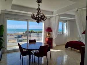 a dining room with a table and a view of the ocean at Plage El Haouzia in El Jadida