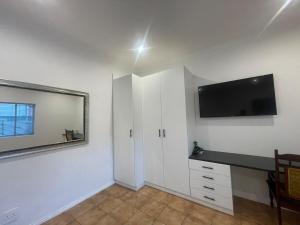 a bedroom with a desk and a television on the wall at Comfort & Convenience in Edenvale