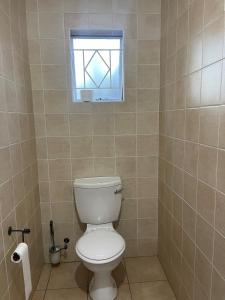 a bathroom with a white toilet and a window at Comfort & Convenience in Edenvale