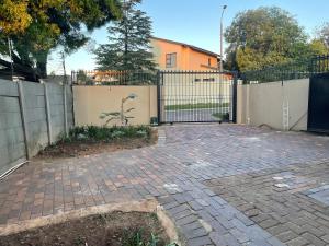 a driveway with a gate and a fence at Comfort & Convenience in Edenvale
