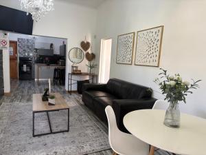 a living room with a black couch and a table at ikibiki in Beaufort West