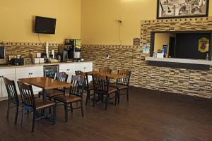 a dining room with tables and chairs and a fireplace at Super 8 by Wyndham Abilene KS in Abilene