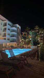 a swimming pool with lounge chairs and a building at Antibes Port - Terrasse - Parking - Piscine in Antibes