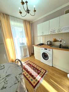 a kitchen with a sink and a washing machine at Двухкомнатная "Аэропорт Астана" in Prigorodnyy