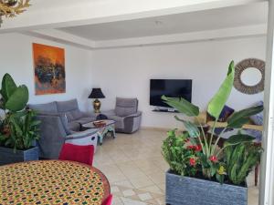 a living room with a couch and a tv at Plage El Haouzia in El Jadida