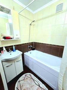 a bathroom with a white tub and a sink at Двухкомнатная "Аэропорт Астана" in Prigorodnyy +18 photos