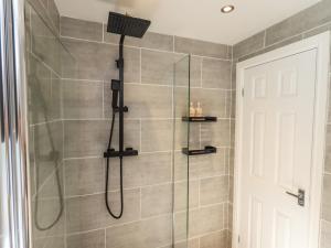 a bathroom with a shower with a glass door at Badgers Hollow Lodge in Windermere +27 photos