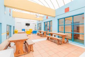 a classroom with benches and tables in a building at HI Faro – Pousada de Juventude in Faro +34 photos