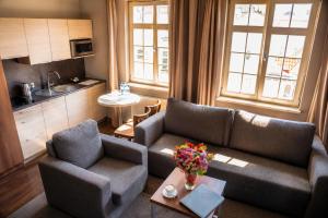 a living room with a couch and two chairs at Apart Neptun in Gdańsk