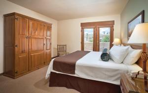 a bedroom with a bed and a cabinet and a window at Taos Resort Studio Apartment in Taos