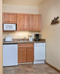 a kitchen with white appliances and wooden cabinets at Taos Resort Studio Apartment in Taos +22 photos