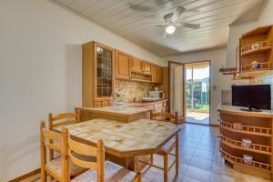a kitchen with a table and chairs and a ceiling fan at Gîtes Villa Beau Soleil Agde in Agde