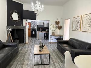 a living room with black leather furniture and a fireplace at ikibiki in Beaufort West