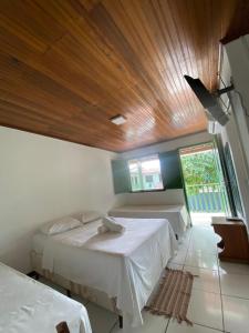 a bedroom with two beds and a wooden ceiling at Pousada Tapuia in Porto Seguro +44 photos