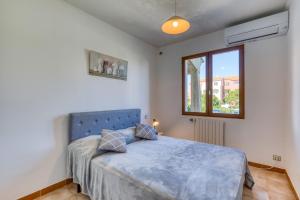 a bedroom with a blue bed and a window at Gîtes Villa Beau Soleil Agde in Agde