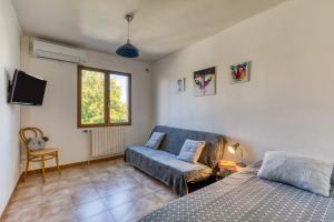 a living room with a bed and a couch at Gîtes Villa Beau Soleil Agde in Agde