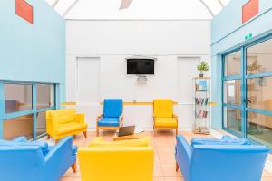 a waiting room with chairs and a tv at HI Faro – Pousada de Juventude in Faro