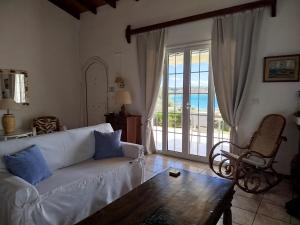 a living room with a couch and a view of the ocean at Votsalo Summer House by the Beach in Porto Heli