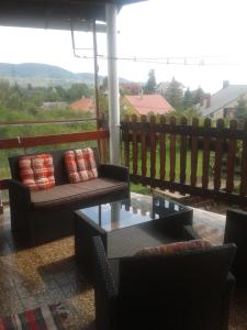 バダチョニトマイにあるVajkai Házのソファとテーブル付きのポーチが備わる眺めの良い客室です。