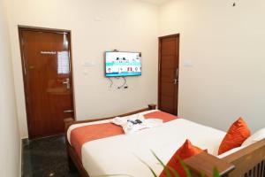 a bedroom with a bed and a flat screen tv at Unique3 in Yercaud