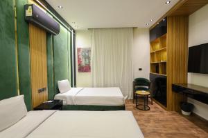 a hotel room with two beds and a television at Elite Boutique Hotel in Cairo