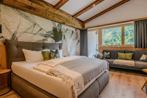 a bedroom with a large bed and a couch at Zillertaler Hofchalets Schustererhof in Stumm