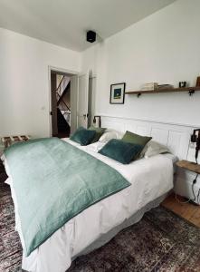 a bedroom with a large white bed with green pillows at MAISON BO TERRA - Chambres et table d'hôtes - Massif des Écrins in Valbonnais