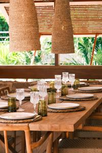 a wooden table with glasses and plates on it at 3 Bedroom Villa with Lagoon View Pool in Marigot