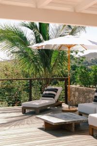a patio with two lounge chairs and an umbrella at 3 Bedroom Villa with Lagoon View Pool in Marigot