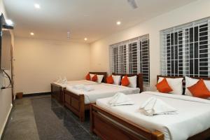 a bedroom with two beds and two windows at Unique3 in Yercaud