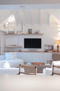 a living room with white furniture and a flat screen tv at 3 Bedroom Villa with Lagoon View Pool in Marigot