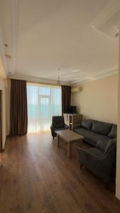 a living room with a couch and a table at Hotel Lazuri in Kvariati