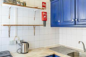 a kitchen with blue cabinets and a sink at HI Faro – Pousada de Juventude in Faro