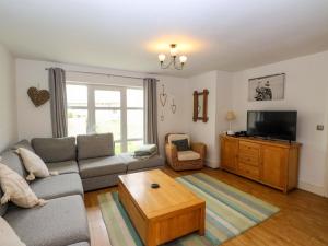 a living room with a couch and a tv at The Bungalow in Pwllheli