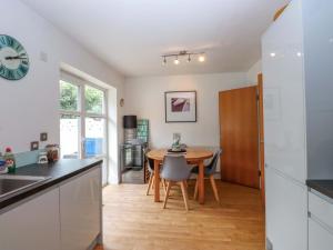 a kitchen and dining room with a table and chairs at The Bungalow in Pwllheli
