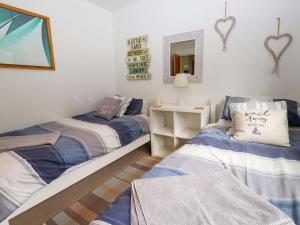 a bedroom with two beds and a mirror at The Bungalow in Pwllheli