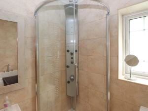 a shower with a glass door in a bathroom at The Bungalow in Pwllheli +12 photos