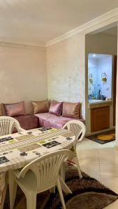 a living room with a table and a couch at Martil, Avenue Oum Kalthoum in Martil