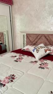 a bedroom with a bed with flowers on it at Martil, Avenue Oum Kalthoum in Martil