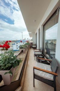 a balcony with benches and flowers on a building at Victory SeaSide Studio in Mangalia