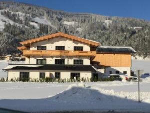 ein großes Gebäude mit Schnee davor in der Unterkunft Eggerbauer in Brixen im Thale