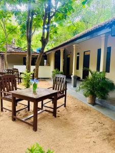 a wooden table and chairs in front of a building at Ocean Bliss in Pottuvil