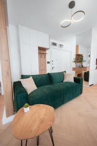 a living room with a green couch and a table at Victory SeaSide Studio in Mangalia