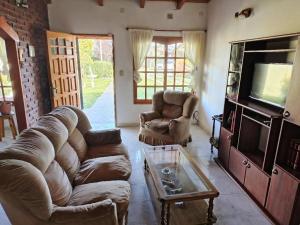 a living room with a couch and chairs and a tv at Fy Lle -Mi lugar- Gaiman in Gaiman