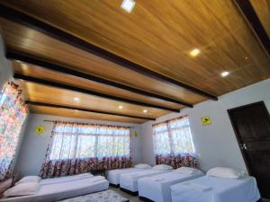 a room with four beds in it with windows at Saqua Beach Hostel in Saquarema +71 photos