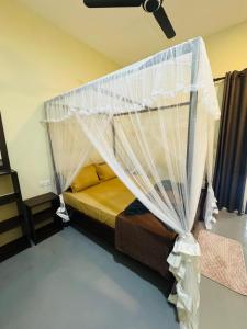 a bedroom with a bed with a mosquito net at Ocean Bliss in Pottuvil