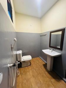 a bathroom with a sink and a toilet and a mirror at Ocean Bliss in Pottuvil
