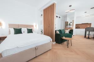a bedroom with a large bed and a green chair at Victory SeaSide Studio in Mangalia